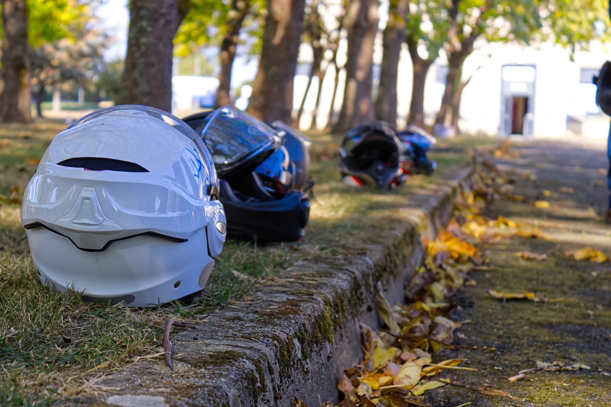 Casques de moto alignés sur un muret pendant la journée Trajectoire en Mayenne