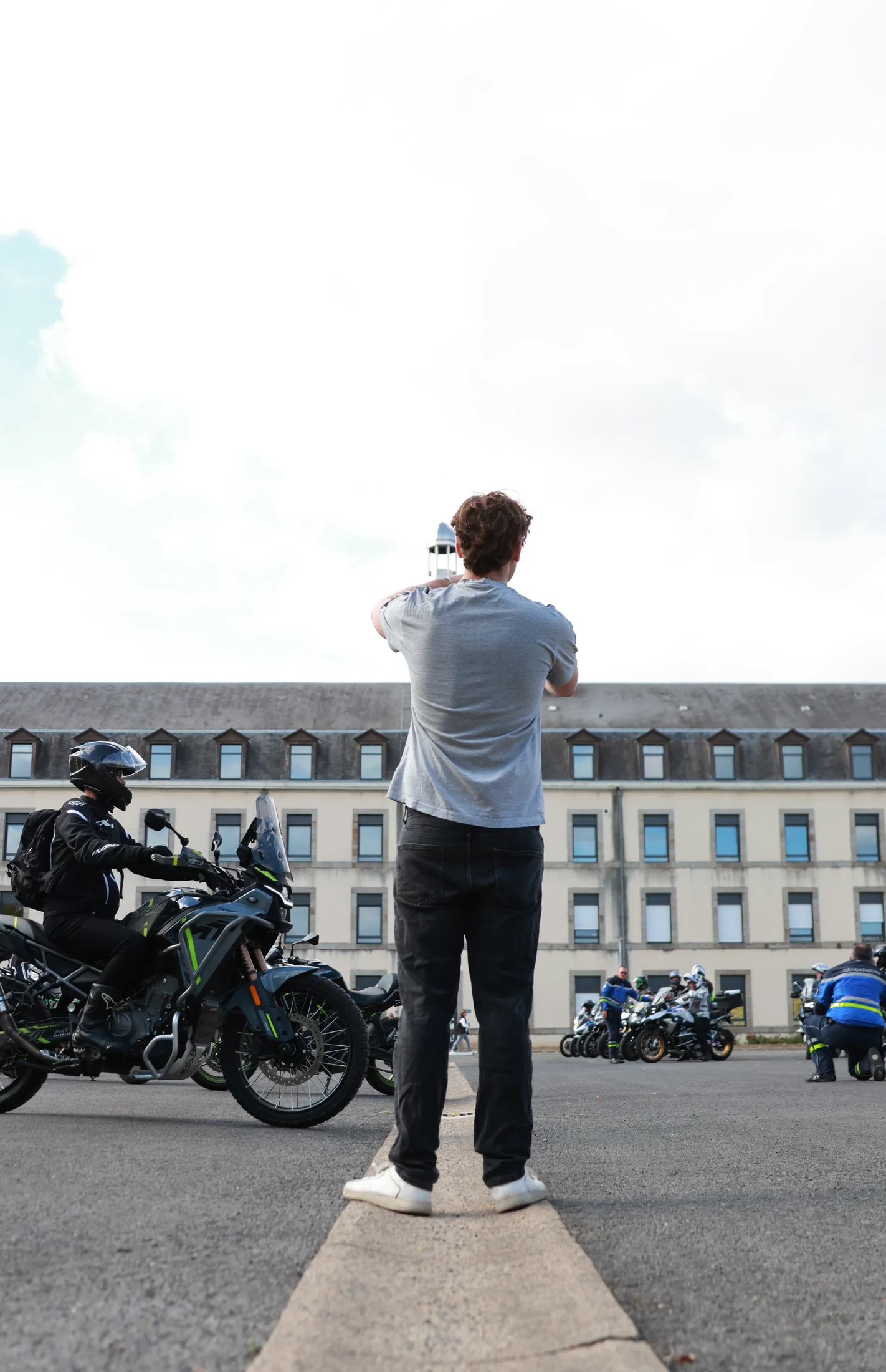 Johan Roisse photographié de dos face aux motards pendant la journée Trajectoire en Mayenne